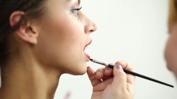 Model and visagiste hand paints underlip with brush — Stock Video