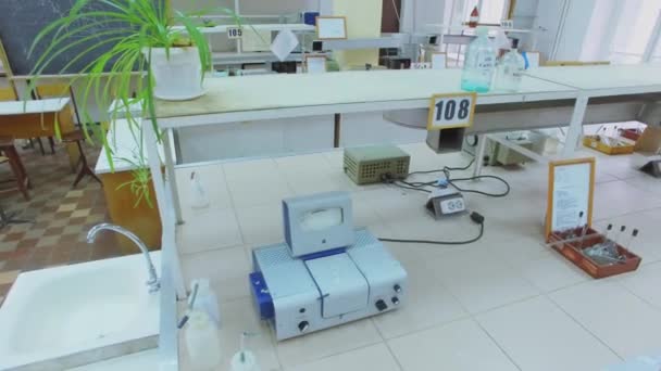 Schreibtische mit Geräten im Labor mit Tafel an der Universität — Stockvideo