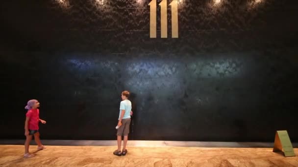 Boy and girl stand near wall with waterfall — Stock Video