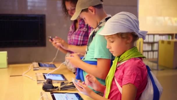 Rodzina patrzy na iPady w sklepie — Wideo stockowe