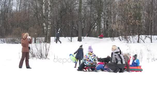 Famílias em trenós andando em encosta de neve — Vídeo de Stock