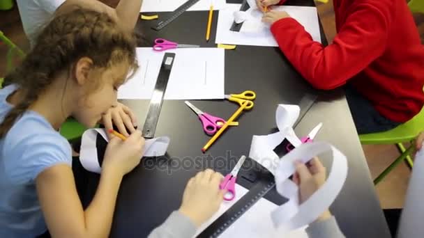 Mesa com artigos de papelaria, em torno do qual sentar as crianças — Vídeo de Stock