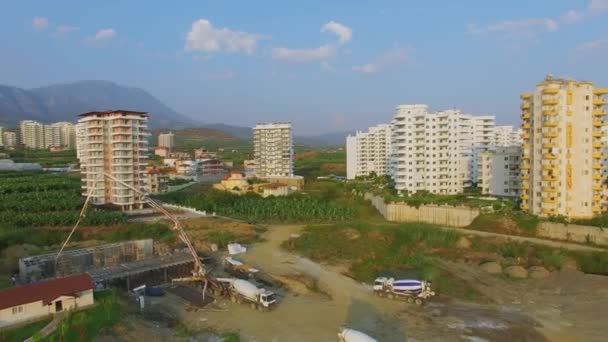 Site de construction à proximité des champs agricoles et des maisons d'habitation — Video