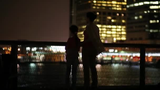 Mujer e hija de pie en el muelle por la noche — Vídeos de Stock