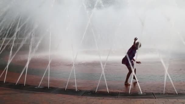 女の子が路上の噴水で遊ぶ — ストック動画