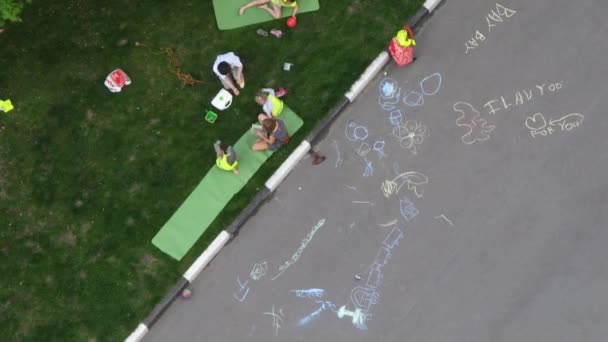 Familie sitzt auf dem Rasen, die Kinder spielen — Stockvideo