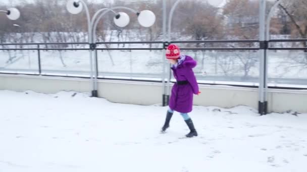 Menina caminha na neve no inverno na cidade — Vídeo de Stock