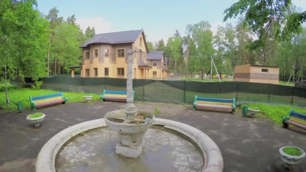 Fontaine et plusieurs maisons résidentielles dans la forêt — Video