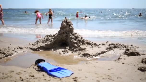 Sand castle, water of sea and resting people — Stock Video