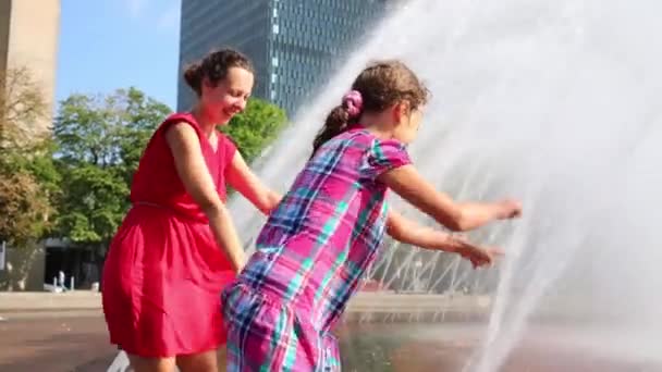 Moeder en dochter touch water van de fontein — Stockvideo