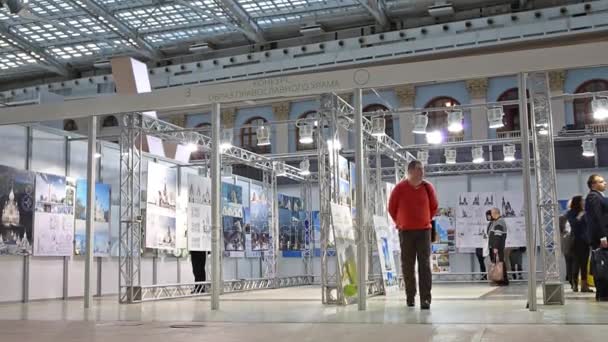 Látogatók keresik a képeket a kiállítás a Gostinyi dvor — Stock videók