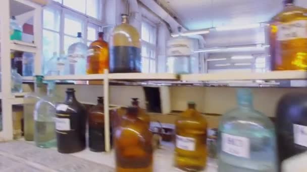 Botellas con reactivos en escritorio y estantes — Vídeo de stock