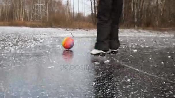 Eiskunstläuferin am zugefrorenen Teich spielt mit Ball — Stockvideo