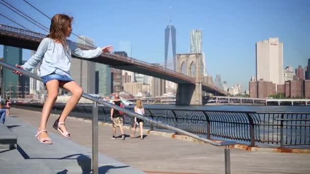Дівчина слайди на перила поблизу Бруклінський міст — стокове відео