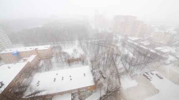 Edifícios na cidade durante a queda de neve no inverno — Vídeo de Stock