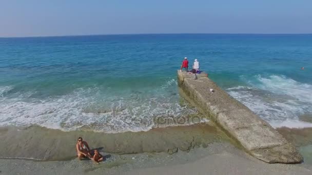 Menschen ruhen sich an der Küste aus — Stockvideo