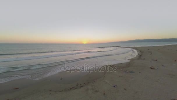 Pessoas na praia durante o pôr do sol — Vídeo de Stock