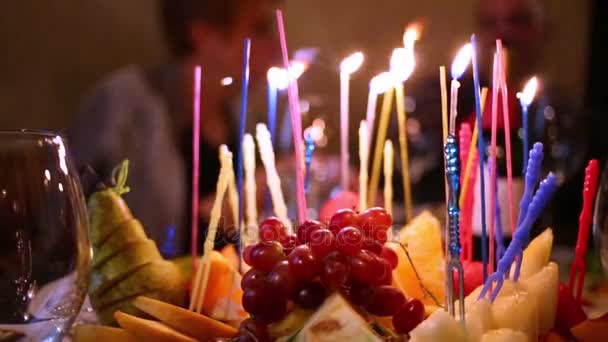 Plate with pieces of fruits and burning candles — Stock Video