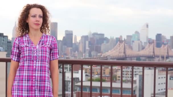 Pretty young woman stands on roof — Stock Video