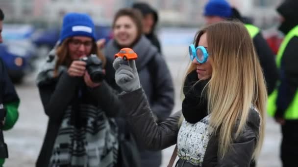 Flicka i glasögon simulera en rattfyllerist poser med leksaksbil — Stockvideo