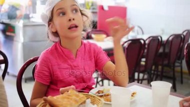 kız yiyor ve masada oturan görüşmeler