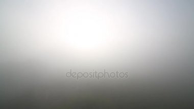 Güneş bir siste şehrin üzerinde parlıyor.