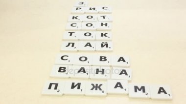 Masanın üzerine mektup--dan oyun Scrabble koydu.