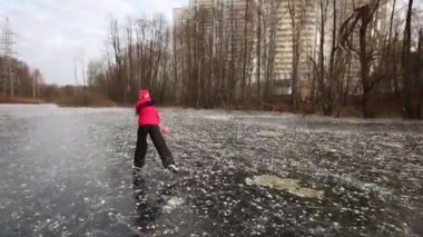 Çocuk patenci ile top oynarken donmuş gölet 