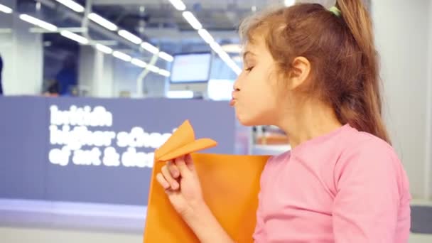 Girl plays with paper plane — Stock Video