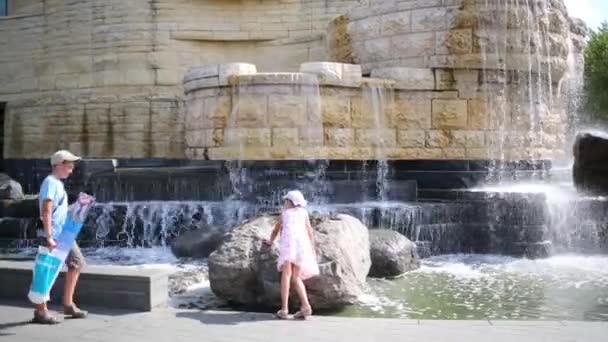 Children plays near beautiful fountain in city — Stock Video