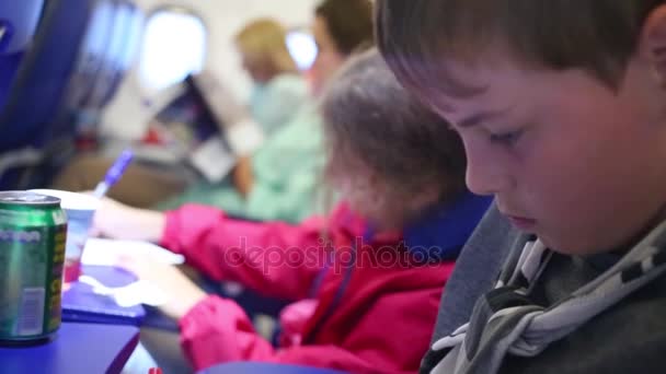 Junge und Mädchen malen auf Zetteln im Flugzeug — Stockvideo