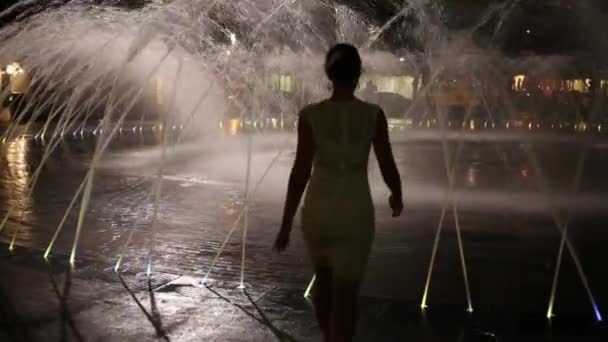 Woman goes into fountain at night — Stock Video