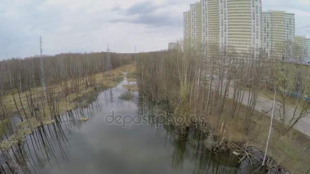Water among plants near residential complex — Stock Video