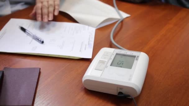 Medizinische Laborangestellte füllen Formular und automatisches Tonometer aus — Stockvideo