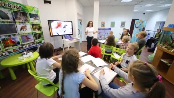 Crianças se senta em sala de aula espaçosa no centro para crianças — Vídeo de Stock