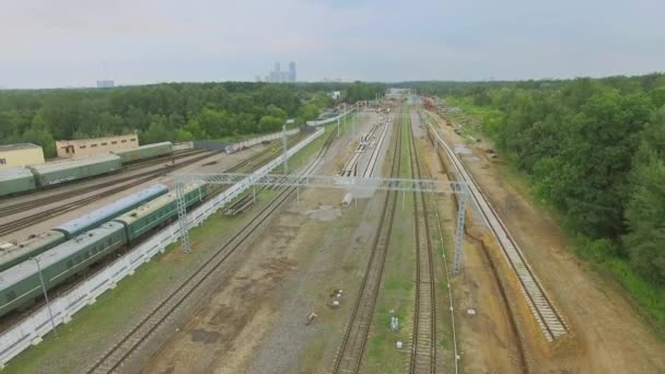 Trenes de recogida cerca del ferrocarril con el sitio de construcción del viaducto — Vídeos de Stock