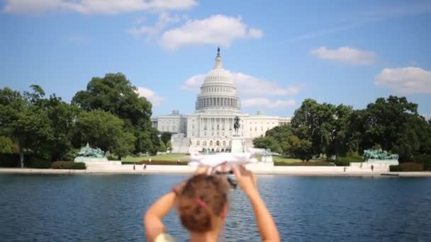 Žena s dívkou a quadrocopter nedaleko rybníka a Capitol — Stock video