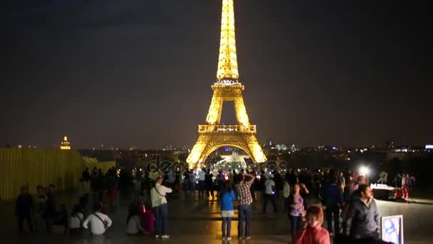 Люди смотрят на Эйфелеву башню ночью в Париже — стоковое видео