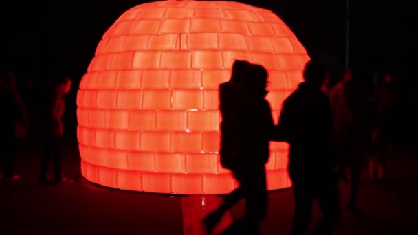 Menschen in der Nähe von rotem Iglu mit Beleuchtung am Lichterkreis — Stockvideo