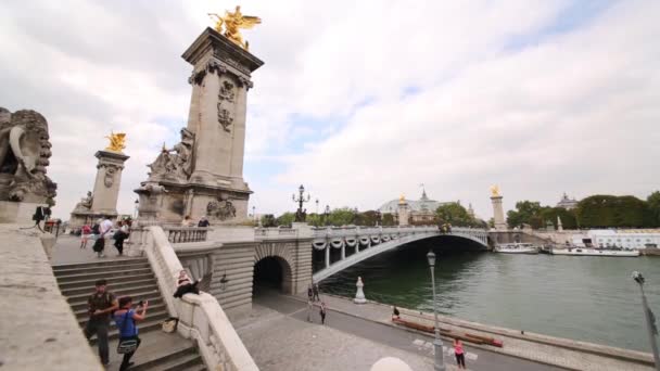 Les gens marchent sur le remblai de la rivière et sur l'escalier du pont — Video