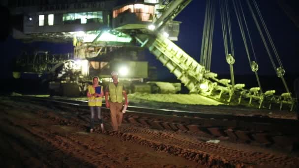 Travailleurs avec des papiers allant à travers la carrière de sable — Video