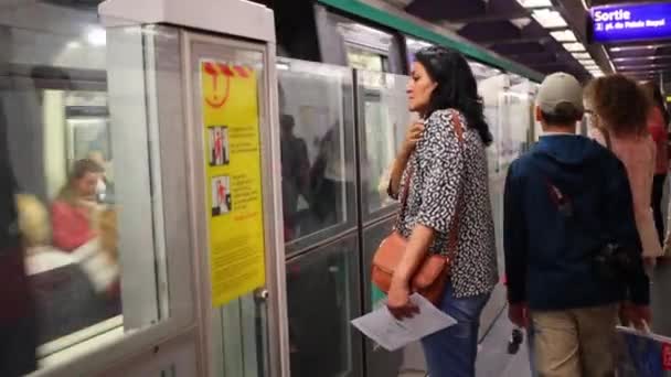 Люди уезжают и садятся в вагон метро в Париже — стоковое видео