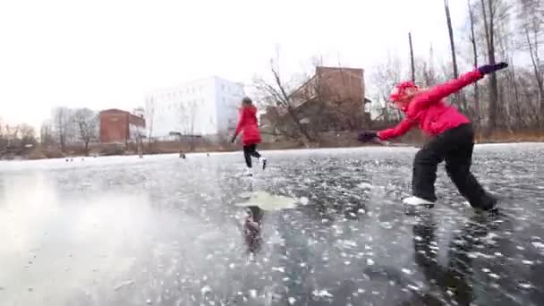 Дочь и мать катаются на коньках по замерзшему болоту — стоковое видео