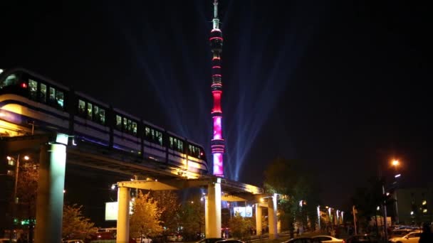 Iluminado torre de televisión Ostankino y tren por la noche — Vídeos de Stock