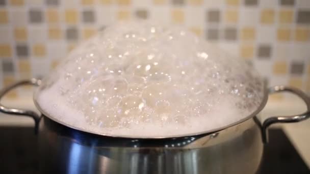 Shiny saucepan of boiling soup with foam on stove — Stock Video