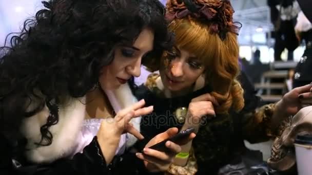 Девушки смотрят в телефон на Everycon — стоковое видео