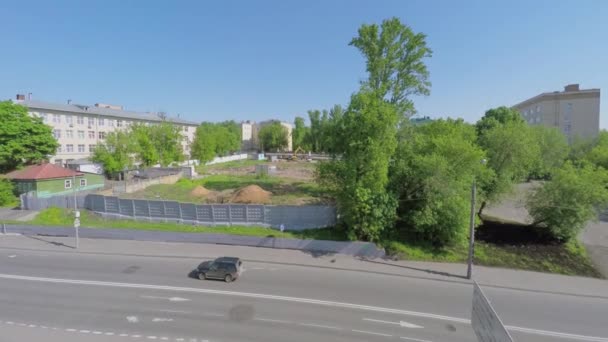 Samochody jeździć przez road w pobliżu ogrodzony plac budowy — Wideo stockowe