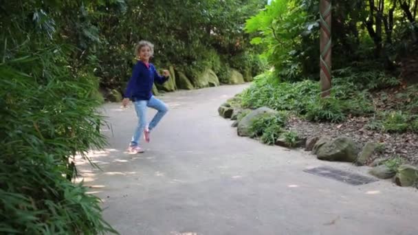 Девушка танцует на дорожке в парке — стоковое видео