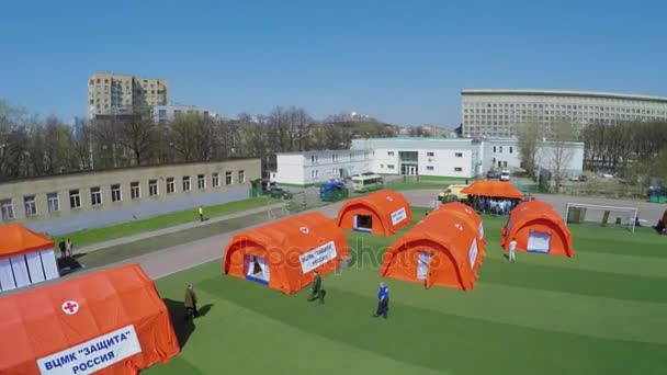 Skara människor som står nära orange tält — Stockvideo