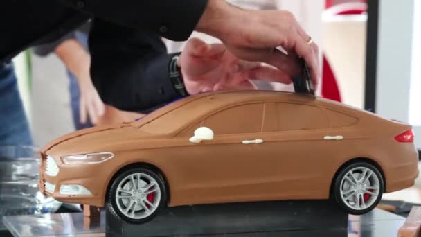Человек сглаживает крышу автомобиля модели — стоковое видео